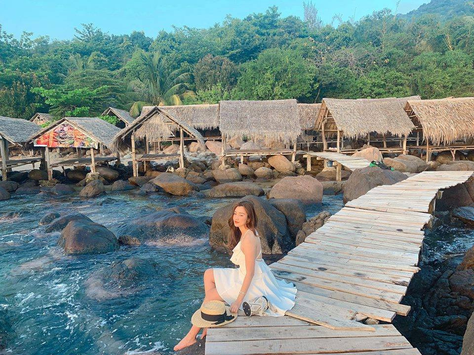 Ngồi trên bãi đá thưởng thức phong cảnh