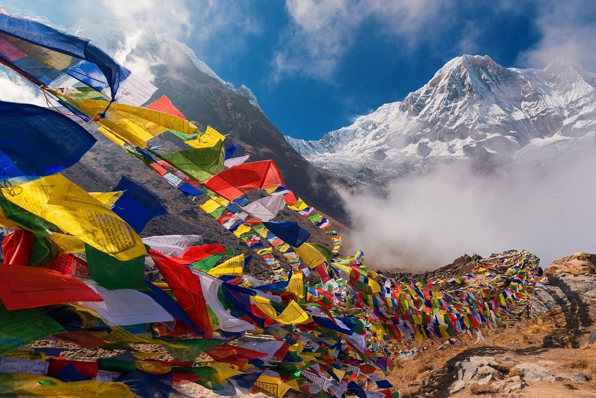Best countries to visit from Hong Kong Prayer flags flutter under the golden sunrise over the majestic Himalayas of Nepal