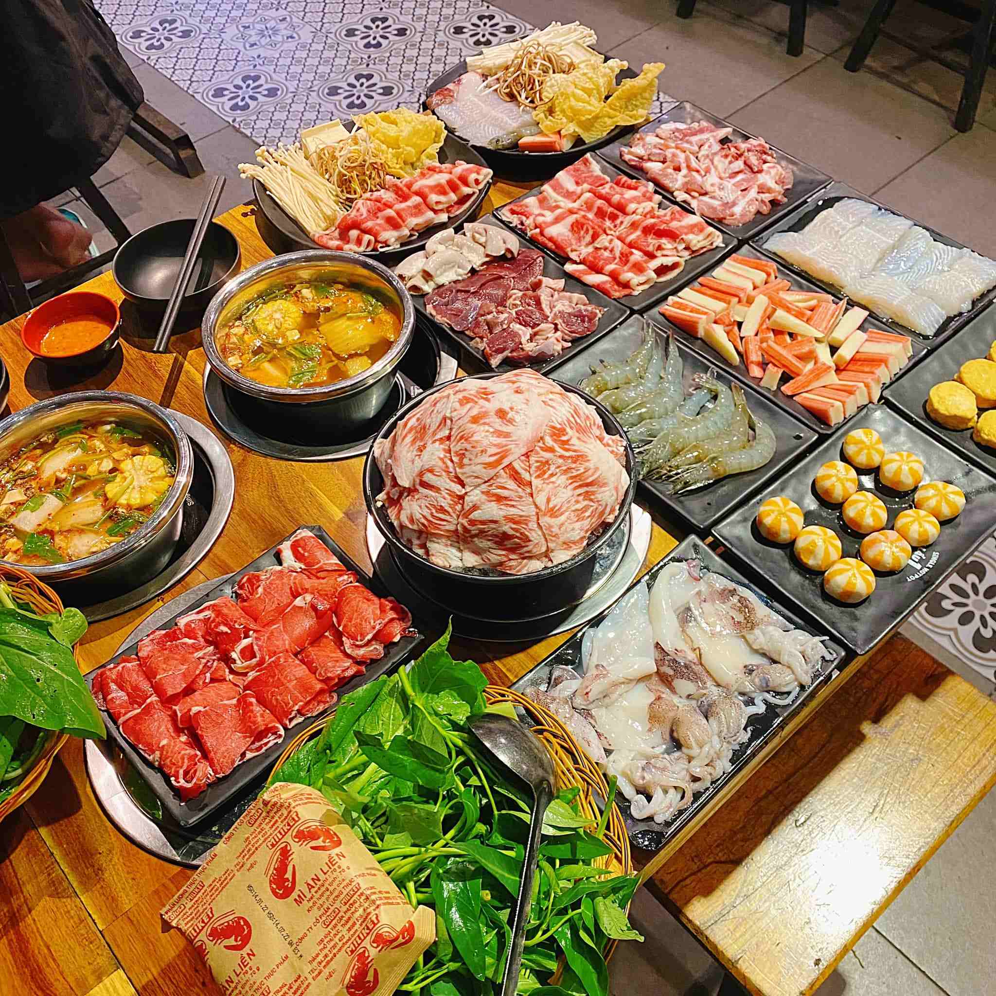 Một bàn đầy ắp các đồ nhúng lẩu tươi ngon 