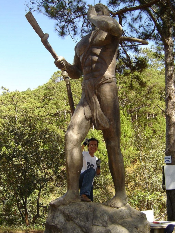 Tượng người dũng sĩ, tay cầm cung tên giơ cao lên trời tại thác Hang Cọp